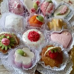 there are many different types of cookies in the tray on the table with lace doily