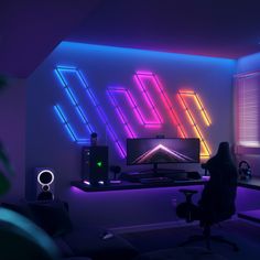 a woman is sitting in front of a computer with neon lights on the wall behind her