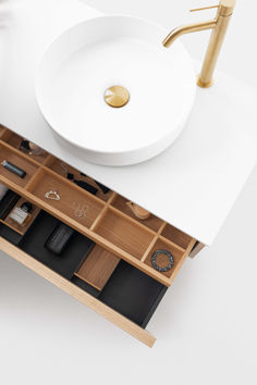 a white sink sitting on top of a bathroom counter next to a wooden cabinet with drawers