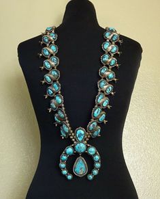 "HUGE 684g VINTAGE LEO ARVISO NAVAJO SQUASH BLOSSOM NECKLACE DESCRIPTION: This massive squash blossom necklace features breathtaking specimens of high blue natural turquoise. The gemstones are secure in smooth bezel, on a foundation of heavy gauge vintage sterling silver. A double row of stamped beads hosts magnificent blossoms, each with 2 cabs of blue turquoise adorned with hand stamped applied leaf and four petal blossom. Please note that one of the turquoise cabs is cracked, but secure in it Western Blue Concho Necklace, Blue Western Style Concho Necklace, Southwestern Blue Concho Necklace, Southwestern Style Blue Concho Necklace, Vintage Blue Turquoise Necklace With Concho, Blue Bohemian Concho Necklace, Bohemian Blue Concho Necklace, Vintage Turquoise Concho Necklace, Western Style Blue Turquoise Collectible Necklace