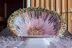 a large fan with flowers on it sitting in front of many wine glasses