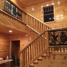 the inside of a cabin with wood walls and stairs