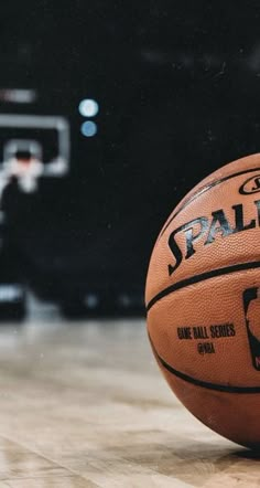 a basketball sitting on top of a wooden floor next to a basket ball with the word spalding written on it