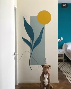 a brown dog sitting in front of a blue and yellow wall