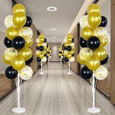 the hallway is decorated with black, gold and white balloons for an elegant party or celebration