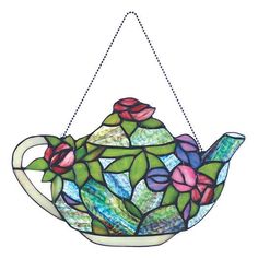 a stained glass teapot with flowers hanging from it's side on a chain