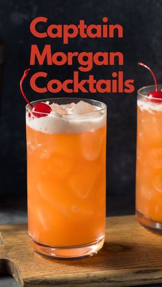 two glasses filled with orange cocktail on top of a wooden table