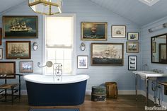 a bathroom with blue walls and pictures on the wall