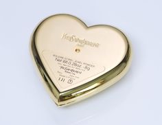 Yves Saint Laurent Heart Compact Limited edition YSL gold tone "jewel powder" compact. Brand new and unopened heart compact with dark green heart-shaped crystal. Comes with box. Approximate Measurements: Length 2.5”, Width 2.6” Made in: France Condition: Brand New Ysl Gold, Makeup Accesories, Ysl Beauty, Vintage Cosmetics, Powder Compact, Green Heart, Amazing Art Painting, Girly Jewelry, Compact Mirror