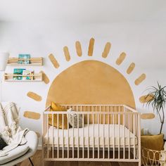 a baby's room with a sun painted on the wall and a white crib