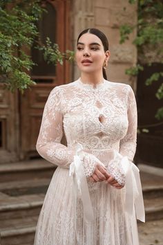 a woman in a white dress standing outside