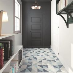 an empty hallway with black doors and white bookshelves on either side of the door