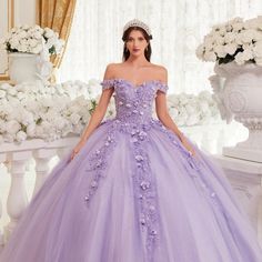 Our Lavender Quinceanera Ball Gown Is A Dreamy Masterpiece For A Magical Celebration! Off-The-Shoulder Sleeves And Lace-Up Corset Back Add Romance, While Layers Of Tulle Create Fairytale Silhouette. The Gown Is Adorned With Three-Dimensional Floral Appliqu, Giving It A Garden-Like Feel. Fabric: Tulle Length: Long Neckline: Off The Shoulder Silhouette: Ball Gown Sleeve: Sleeveless Back: Lace Up Back Skirt: Layered Embellishments: Floral Applique Occasion: Romantic Date/Evening/Dinner, Wedding/Bri Quinceanera Dresses Lilac, Purple Gown For Debut, Purple Wedding Dress The Bride, Purple 15 Dresses Quinceanera, Ball Gowns Purple, Fairytale Silhouette, Rapunzel Quinceanera, Big Princess Wedding Dresses, Gown For Debut