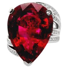 A large and impressive pear-shape rubellite tourmaline weighing in at 18.65 carats. It has a rich and vibrant red color that glows it in light and is set in the center of a chic platinum ring with waves of movement. There are 0.53 carats of round brilliant-cut diamonds set over the waves of platinum running up and down the sides of the ring. Hand-fabricated in platinum, this lovely rubellite ring is ready to be worn and loved. Ring Size 7.5 Weight: 24.6 grams Rubellite Ring, Diamond Pendants Designs, Rubellite Tourmaline, Ring Hand, Platinum Ring, Pendant Design, Round Brilliant Cut Diamond, Cocktail Ring, Pear Shape