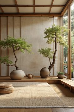 two bonsai trees in vases sitting on a wooden floor next to a bench