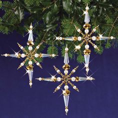 an ornament hanging from a christmas tree with gold and white decorations on it