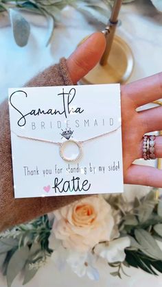 the bridesmaid bracelet and wedding rings are on display in front of some flowers