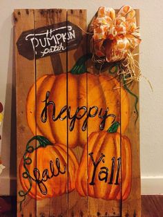 a wooden sign with pumpkins painted on it