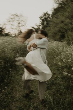 a man and woman are hugging in a field