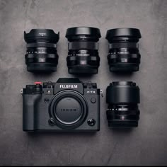 several different types of cameras sitting next to each other on top of a gray surface