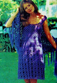 a woman in a purple dress is standing on the grass with her arms behind her head