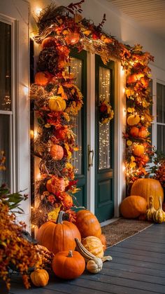 pumpkins and gourds are arranged on the front porch