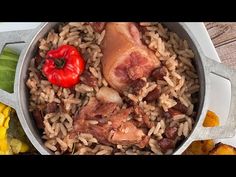 a pot filled with rice and meat next to corn