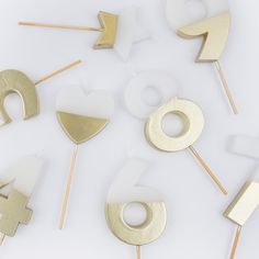 gold and white cupcake toppers are arranged in the shape of numbers on sticks