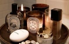 an assortment of perfumes and candles on a tray