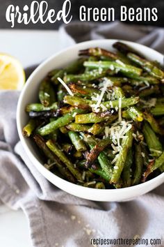 grilled green beans with parmesan cheese in a white bowl on a gray napkin