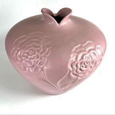 a pink heart shaped vase with roses on it