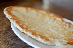 an uncooked flat bread on a white plate