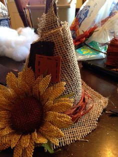 a sunflower sitting on top of a table next to a burlap cone