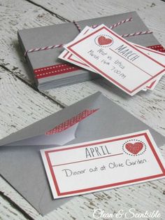 two gray envelopes with red and white designs on them, one is for an event