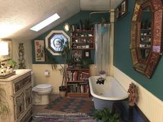 a bathroom with a tub, toilet and sink in it's center area next to a bookshelf