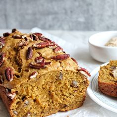 a loaf of pumpkin pecan bread next to a bowl of oatmeal