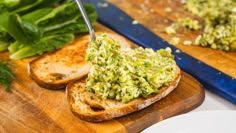 a wooden cutting board topped with bread and guacamole