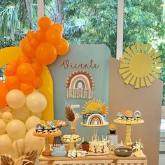 a dessert table with orange and white balloons