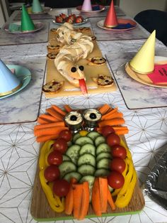 a table topped with lots of different types of vegetables and owls on top of them