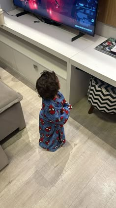 a small child standing in front of a tv