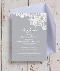 the wedding anniversary party card is displayed on top of a white wooden table with an envelope