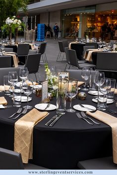 the tables are set for an event with place settings and centerpieces on them