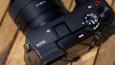 a close up of a camera on a wooden surface with the lens facing upwards and to the left