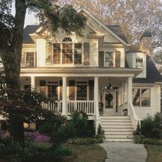 a white house with lots of windows on the front porch and stairs leading up to it