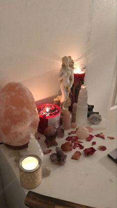 a table topped with lots of different types of candles and rocks on top of it