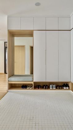 an empty room with white cabinets and shoes on the floor