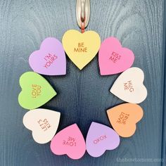 a wreath made out of paper hearts with the words be mine written on them in different colors