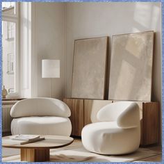 two white chairs and a table in a room