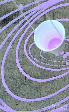 a white bucket sitting on top of a cement floor next to purple circles and lines