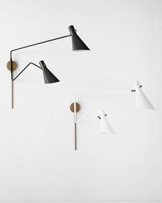 three lamps are hanging on the wall next to each other, one is black and one is white